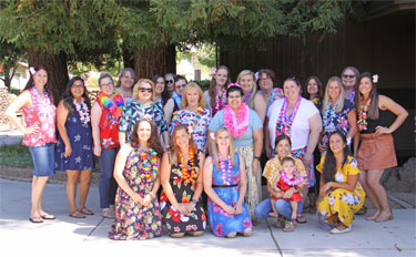 Large group photo of team members dressed in Hawaiian clothing