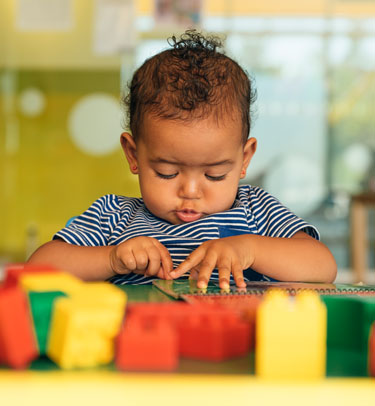 A toddler plays with building blocks.