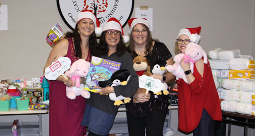 A group of volunteers show off donations made around the holidays,