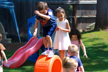 A group of children play on a slide.